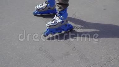 穿蓝色溜冰鞋的男孩骑在公园里